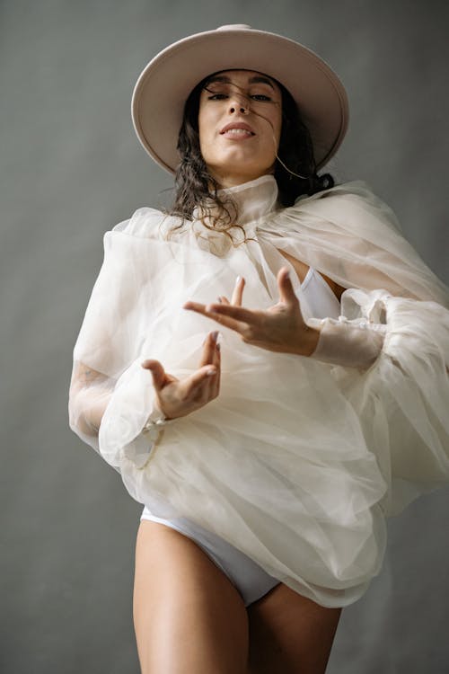Free Low Angle Studio Shot of a Model Wearing See Through Fabric and Hat  Stock Photo