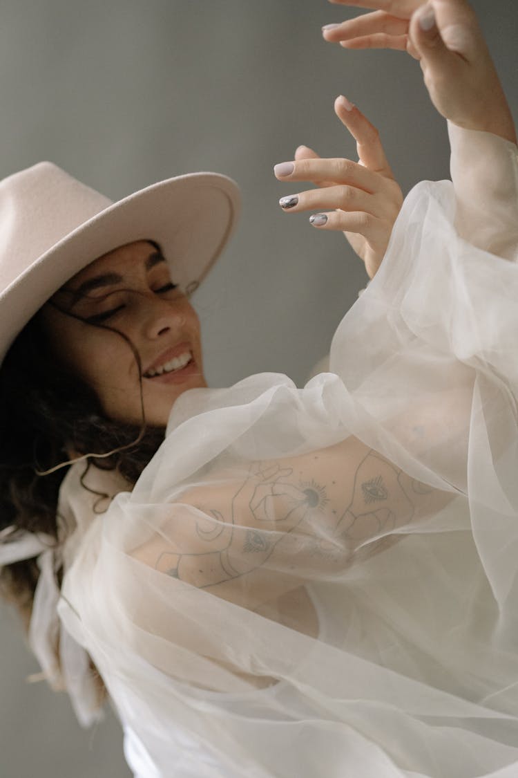 A Woman With See Through Top And Hat Smiling