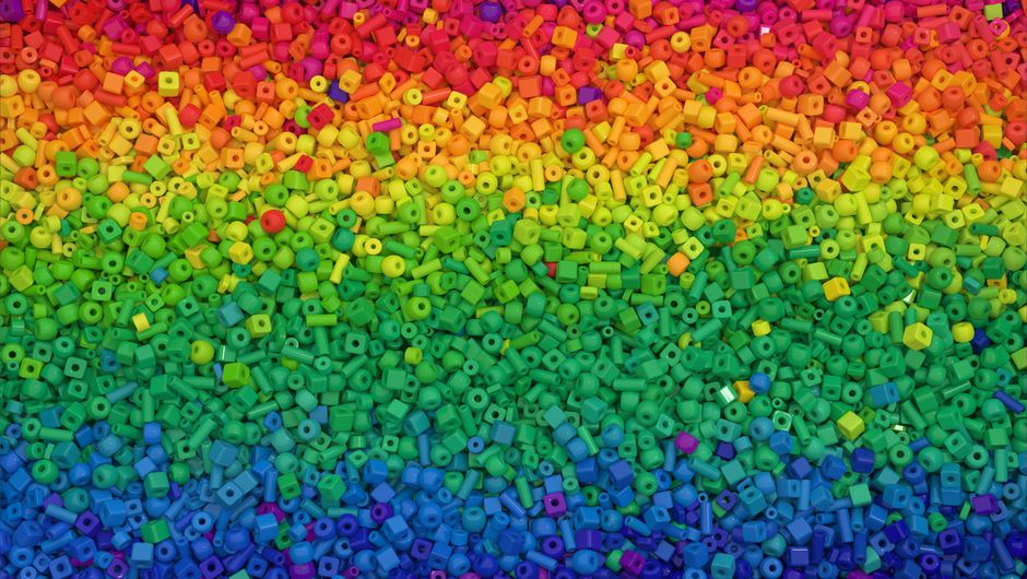 Vibrant close-up of colorful beads arranged in a rainbow pattern, perfect for crafts and DIY projects.