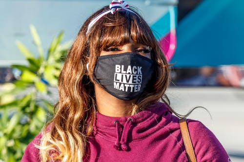 Woman in Purple Jacket Wearing Black Facemask 