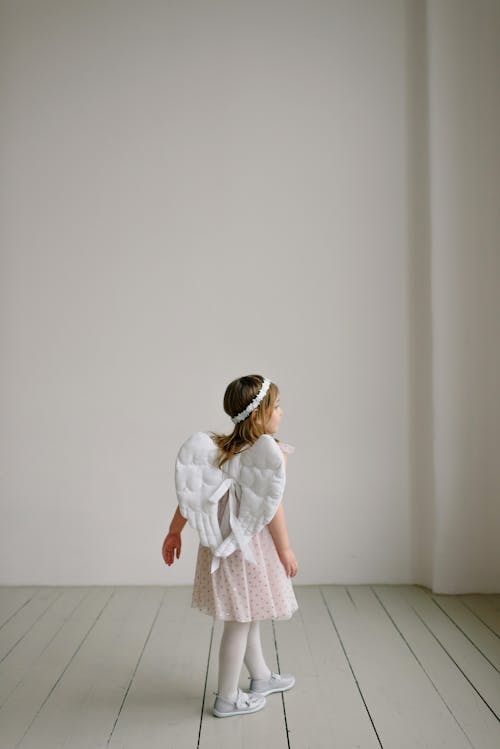 Free Girl in Angel Costume in White Room Stock Photo