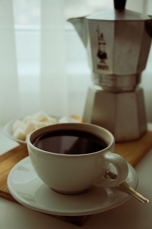 Free A warm coffee served in a porcelain cup with a moka pot on a wooden board. Stock Photo
