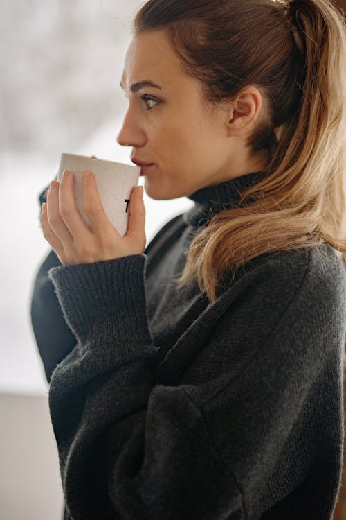 Woman in Black Sweater Holding White Mug