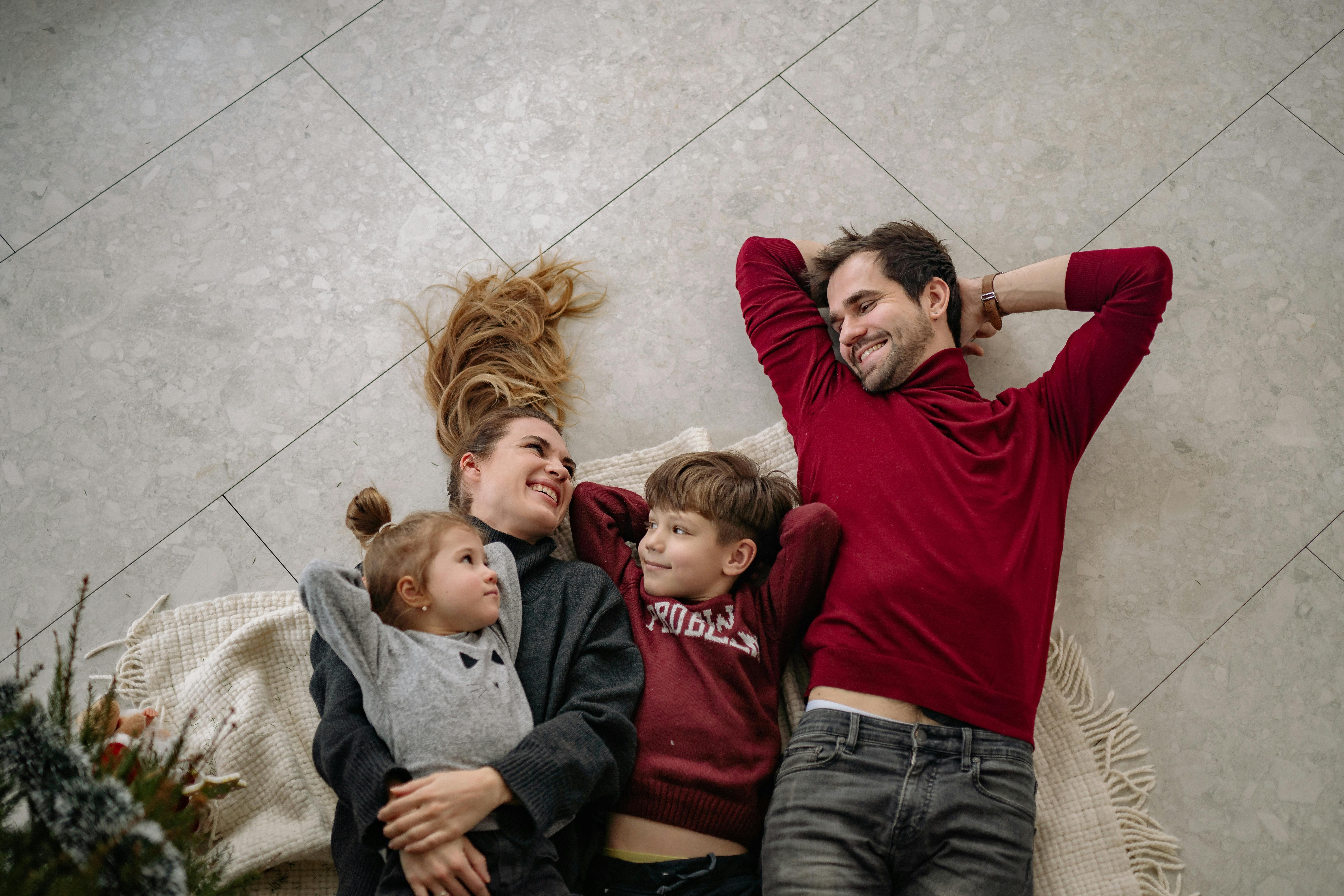 A Family Lying on White Blanket on the Floor · Free Stock Photo