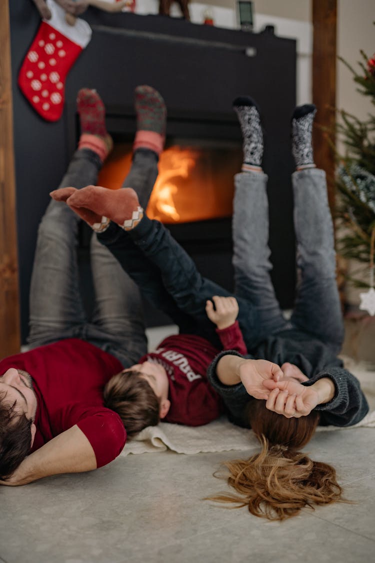 A Family Lying On The Floor Putting Legs Up