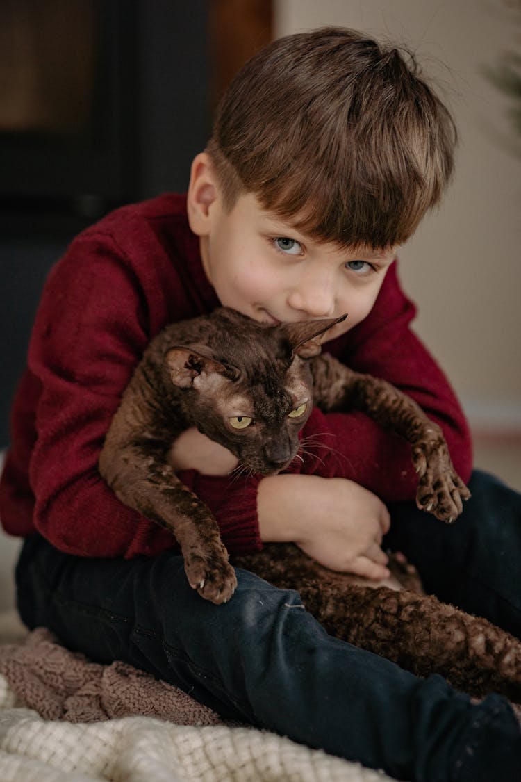 A Kid Hugging A Cat 