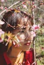 Portrait of a Brunette Woman with Cherry Tree Branches in front of a Face