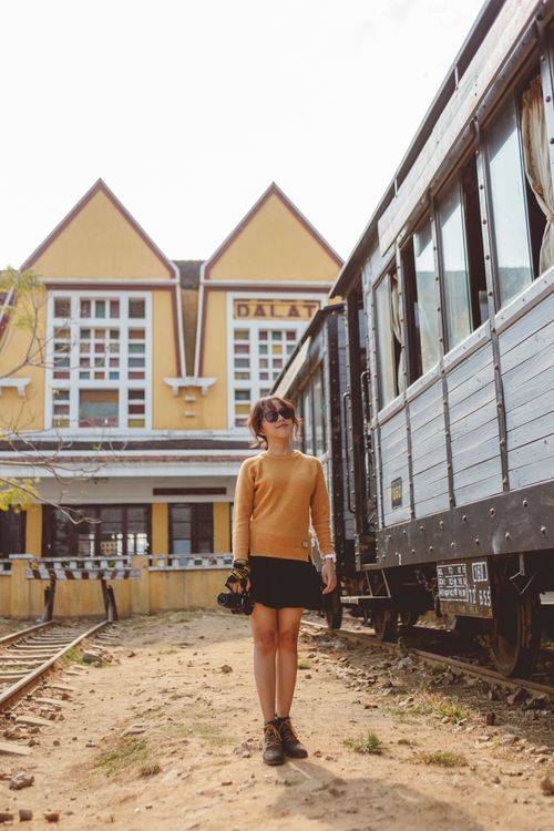 Free Asian woman standing near vintage train at Da Lat station, Vietnam. Stock Photo