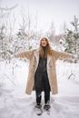 A Happy Woman Standing in the Snow with Arms Outstretched