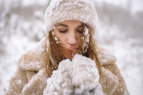 Close-Up Photo of Woman blowing Snow