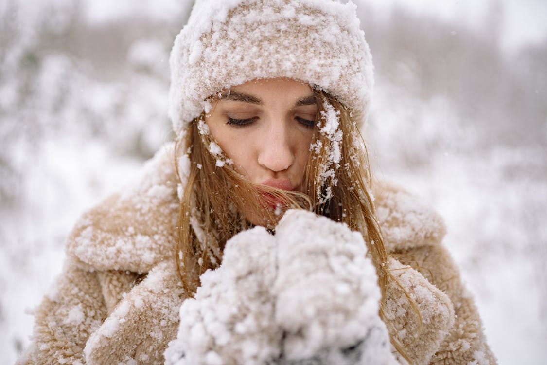 Free Close-Up Photo of Woman blowing Snow Stock Photo