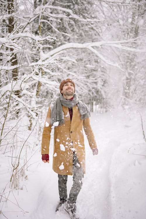 Man in Brown Coat standing on Snow