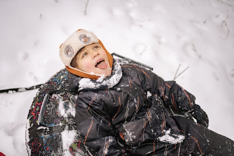 A Kid In Winter Clothing Having Fun Playing In The Snow