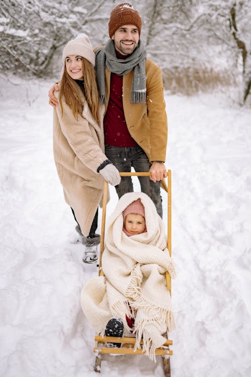 A Happy Family Standing on Snow-Covered Ground