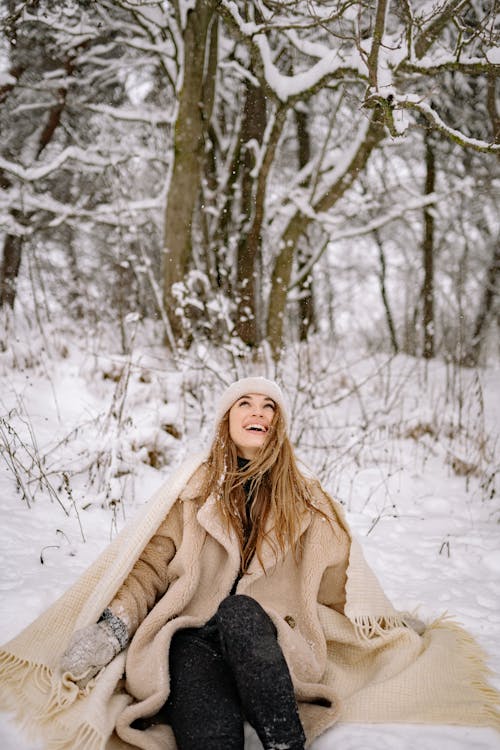 A Woman With a Fur Coat Sitting on the Snow