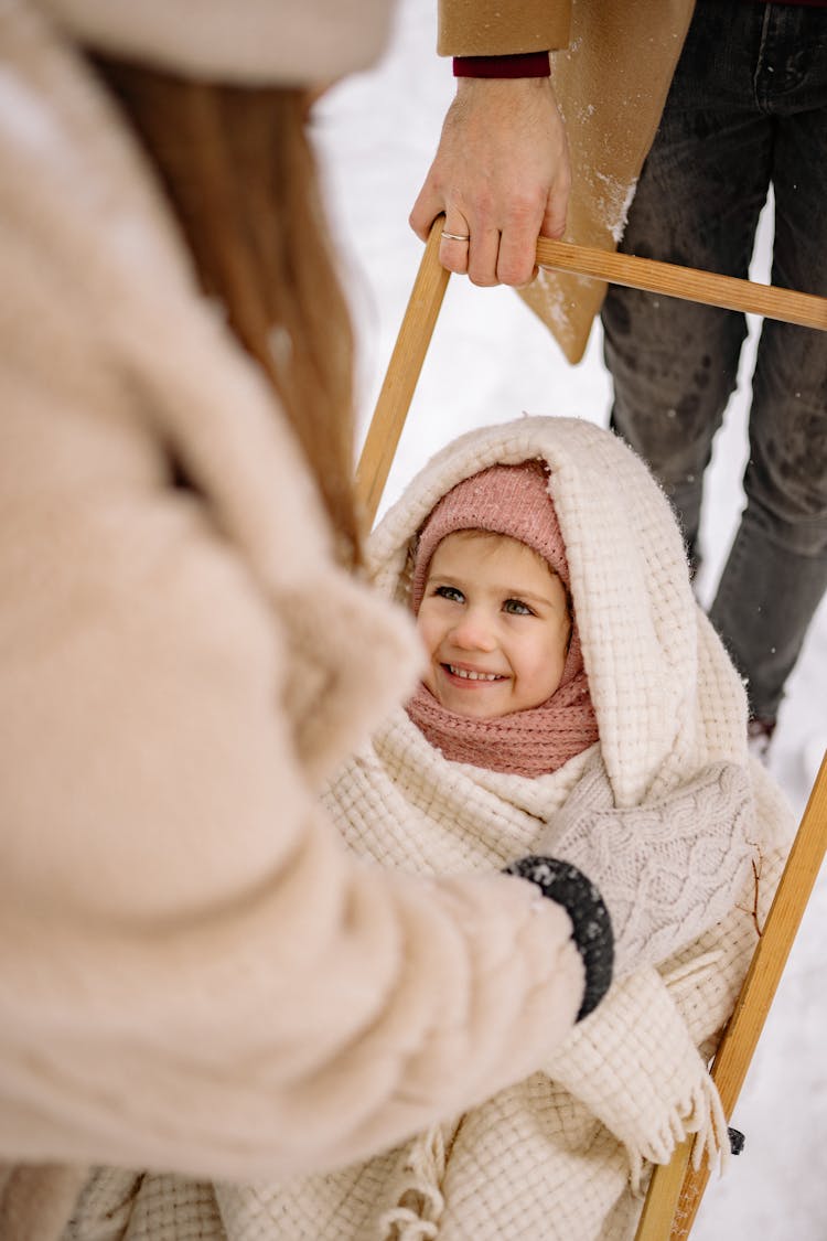 Family With A Girl In Pram Covered With A Blanket In Winter