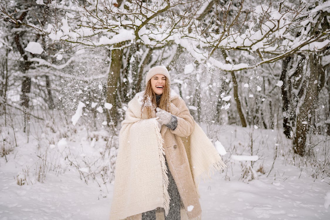 A Woman Standing on the Snow Covered Ground