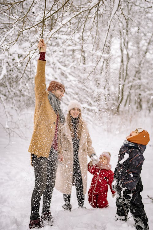 Niños felices con ropa de invierno en la nieve.