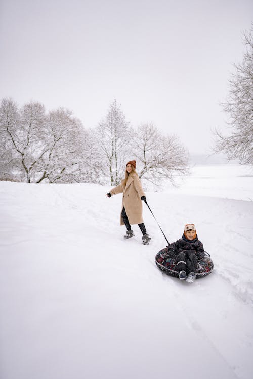 A Family Having Fun Playing in the Snow-Covered Ground