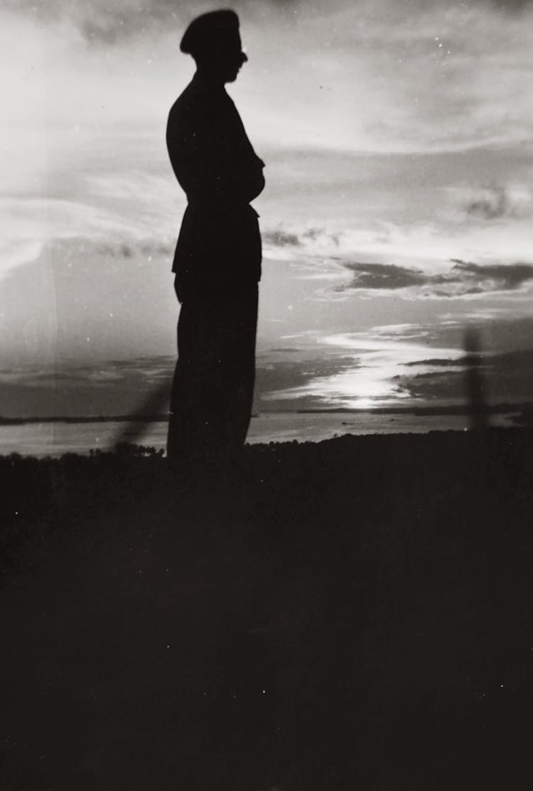 Silhouette Of Man Standing Sideways On Seashore