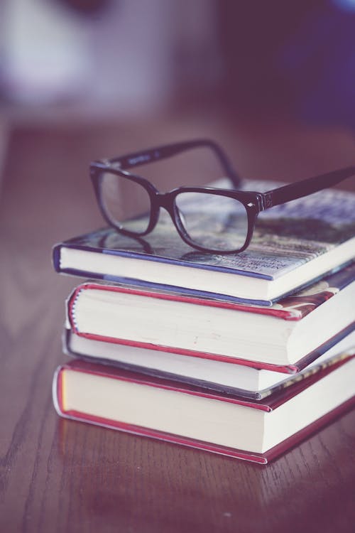 Free A Black Framed Eyeglasses on Stack of Books Stock Photo