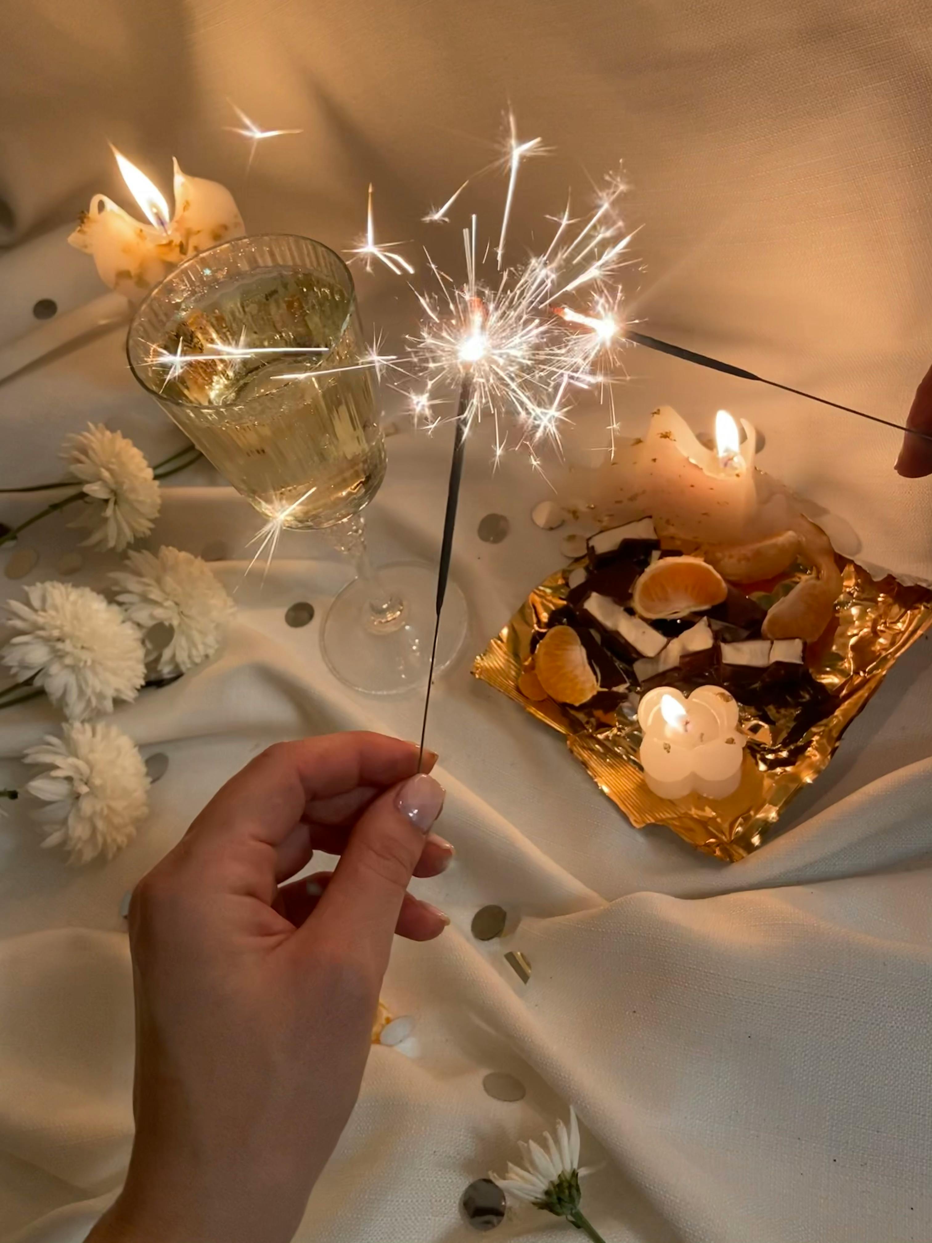 crop woman with sparkler in decorated room