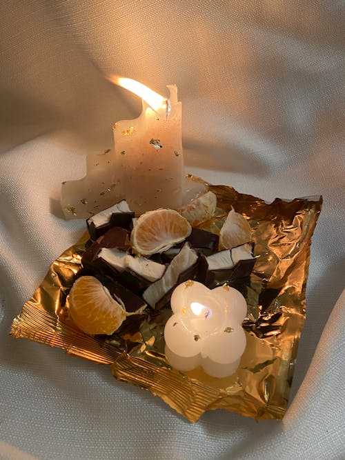 Burning candle on tray with food