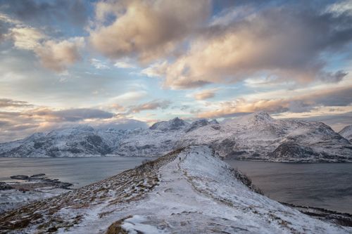 Free Stunning snowy mountain landscape with a serene lake and frosty peaks under a dramatic sky. Stock Photo