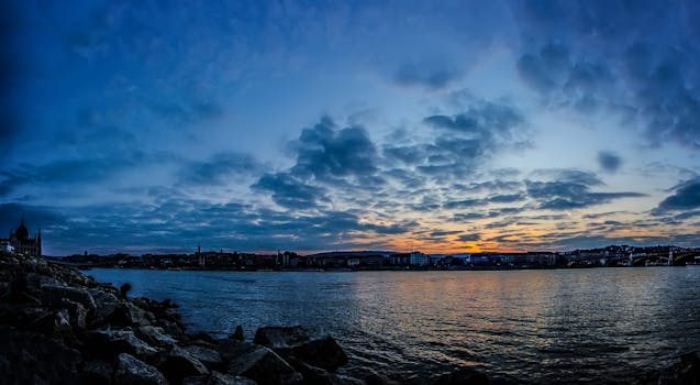 Breathtaking twilight view of Budapest skyline with vibrant sky and river reflections.