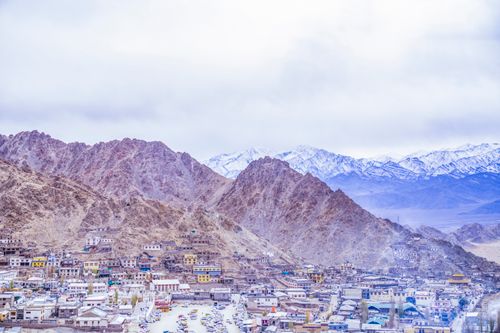 Free Scenic aerial view of Leh town surrounded by rugged Himalayas and snowcapped peaks in winter. Stock Photo
