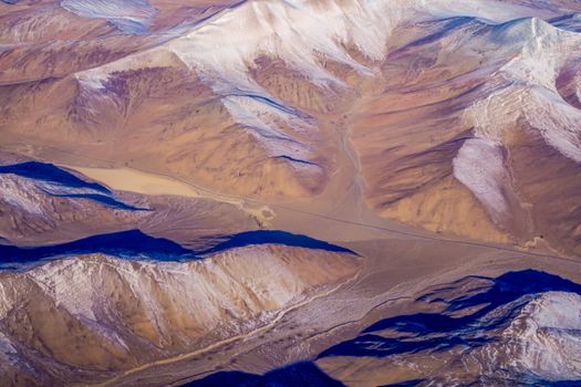 Breathtaking aerial view of snow-capped mountains under a clear sky.