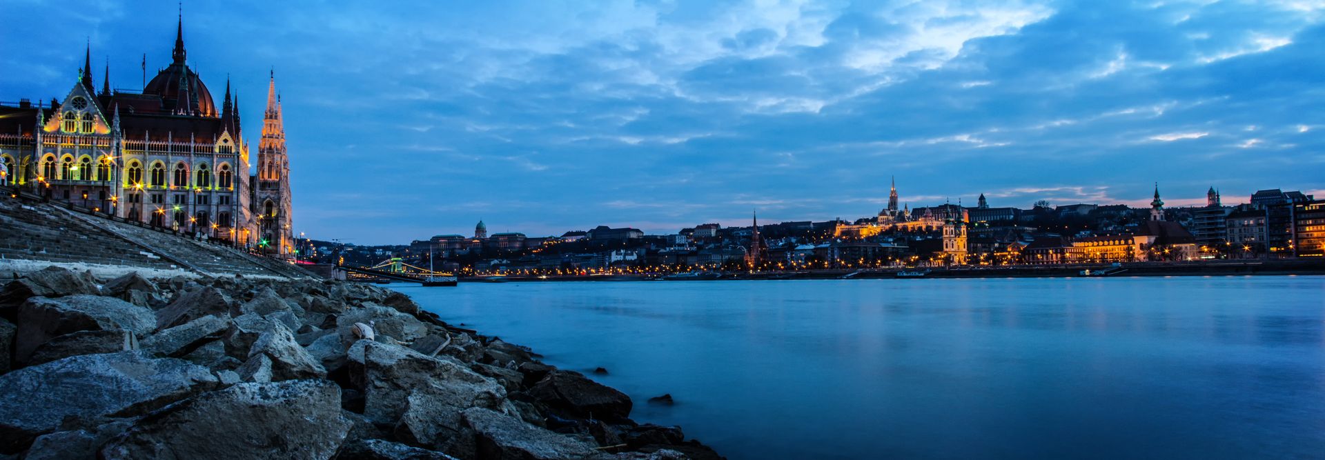 Budapeşte Parlamentosu Tuna Nehri kenarında akşam ışıkları altında.