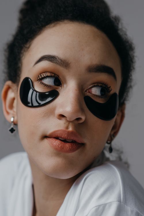 Free Close-up portrait of a woman with under-eye skincare patches, showcasing beauty routines. Stock Photo