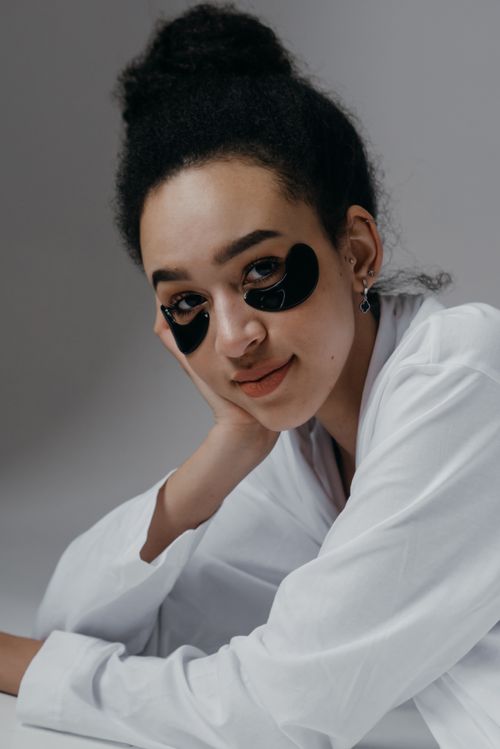Free Portrait of a woman wearing black under eye masks, showcasing skincare routine. Stock Photo