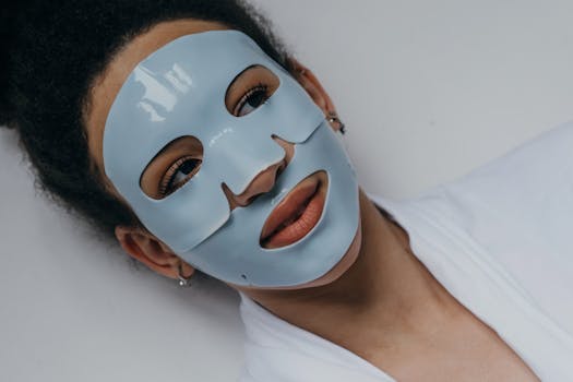 A woman with a blue face mask lies relaxed, enhancing her skin with a beauty treatment.