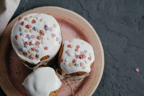 Free Top view of Easter cakes with vibrant sprinkles on a decorative plate, perfect for festive celebrations. Stock Photo