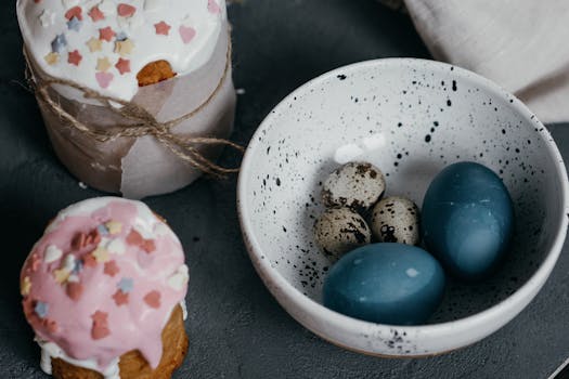 A cozy and artistic Easter display featuring colorful eggs and sprinkled cakes on a rustic background.