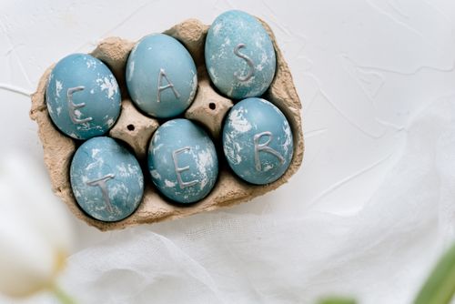 Free Top view of blue dyed Easter eggs in a carton spelling 'EASTER'. Stock Photo