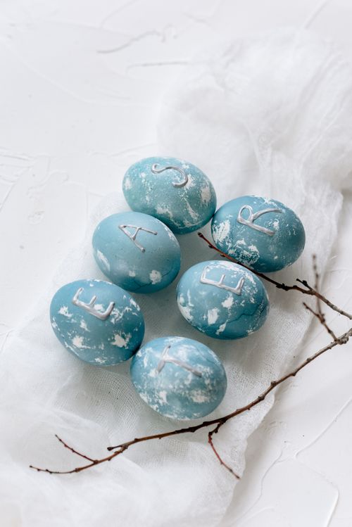 Free Beautifully crafted blue Easter eggs with letters on a soft white background for a festive touch. Stock Photo