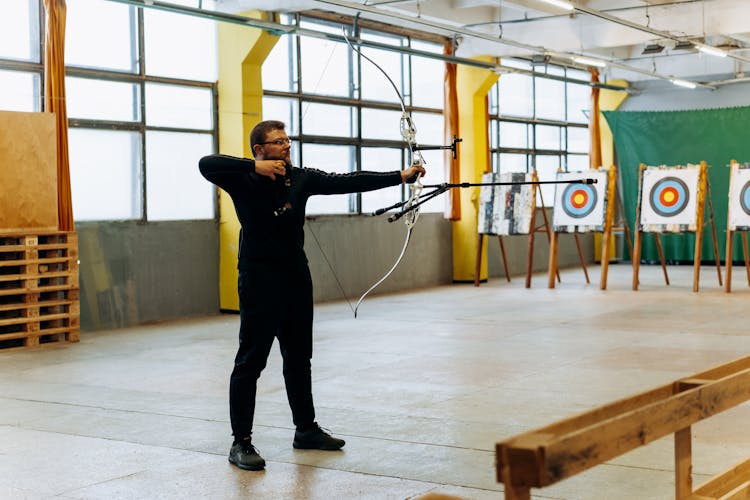 Man In Black Clothes Aiming Bow