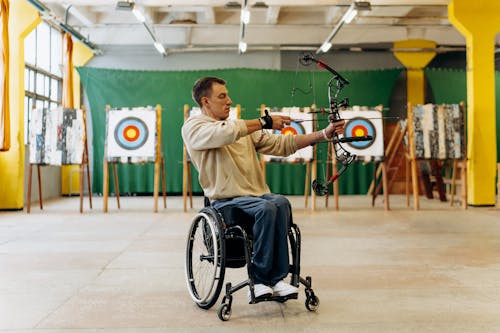 Homme concentré pratiquant le tir à l’arc en salle