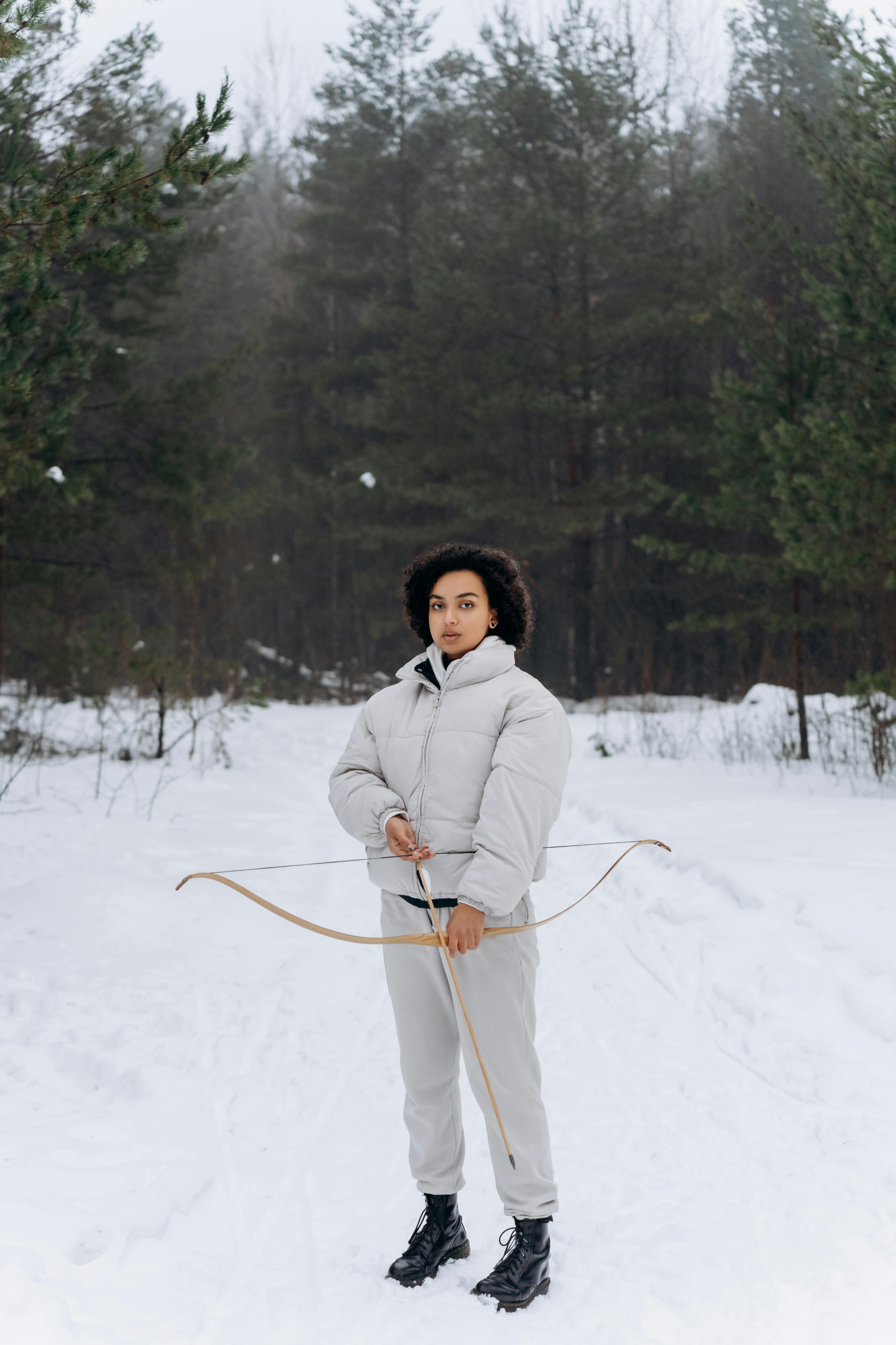 woman in white coat standing on snow covered ground