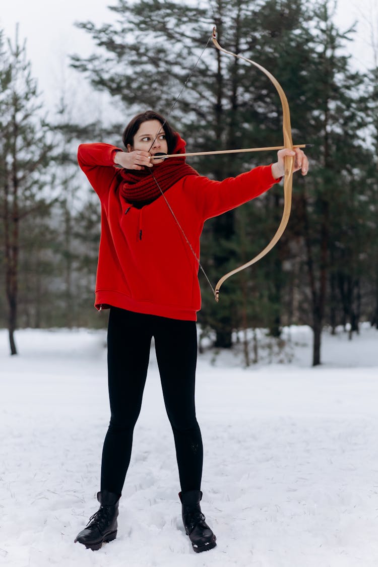 Woman In Red Sweater Shooting A Bow And Arrow