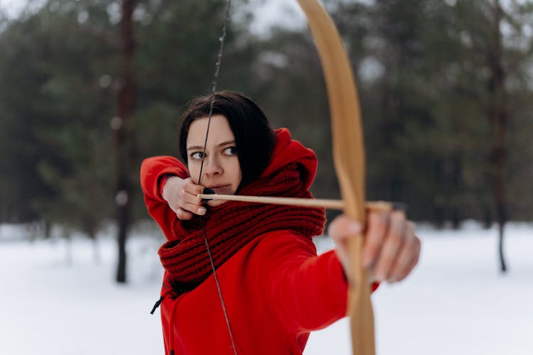 Woman In Red Jacket Shooting A Bow And Arrow