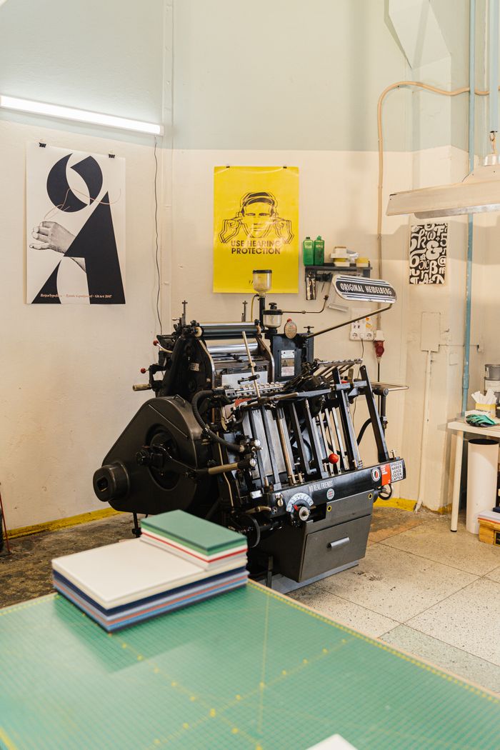 Print studio with a press and fresh posters pinned to the wall