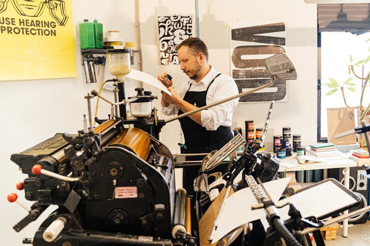 Man Working With Printing Tools Using Machinery