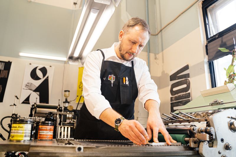 Designer reviewing a branded print layout on screen