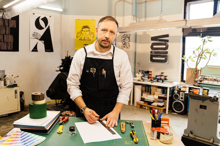 Portrait Of A Graphic Artist In A Studio With Posters On Walls