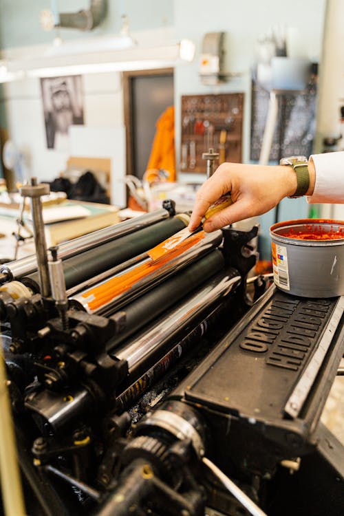 Hand of Man Working with Printing Tools using Machinery