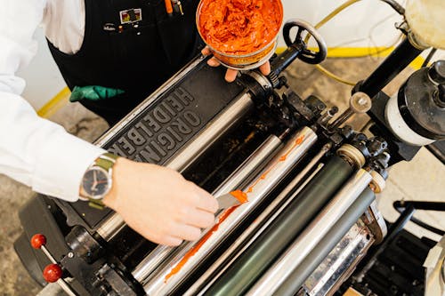 Hand of Man Working with Printing Tools using Machinery